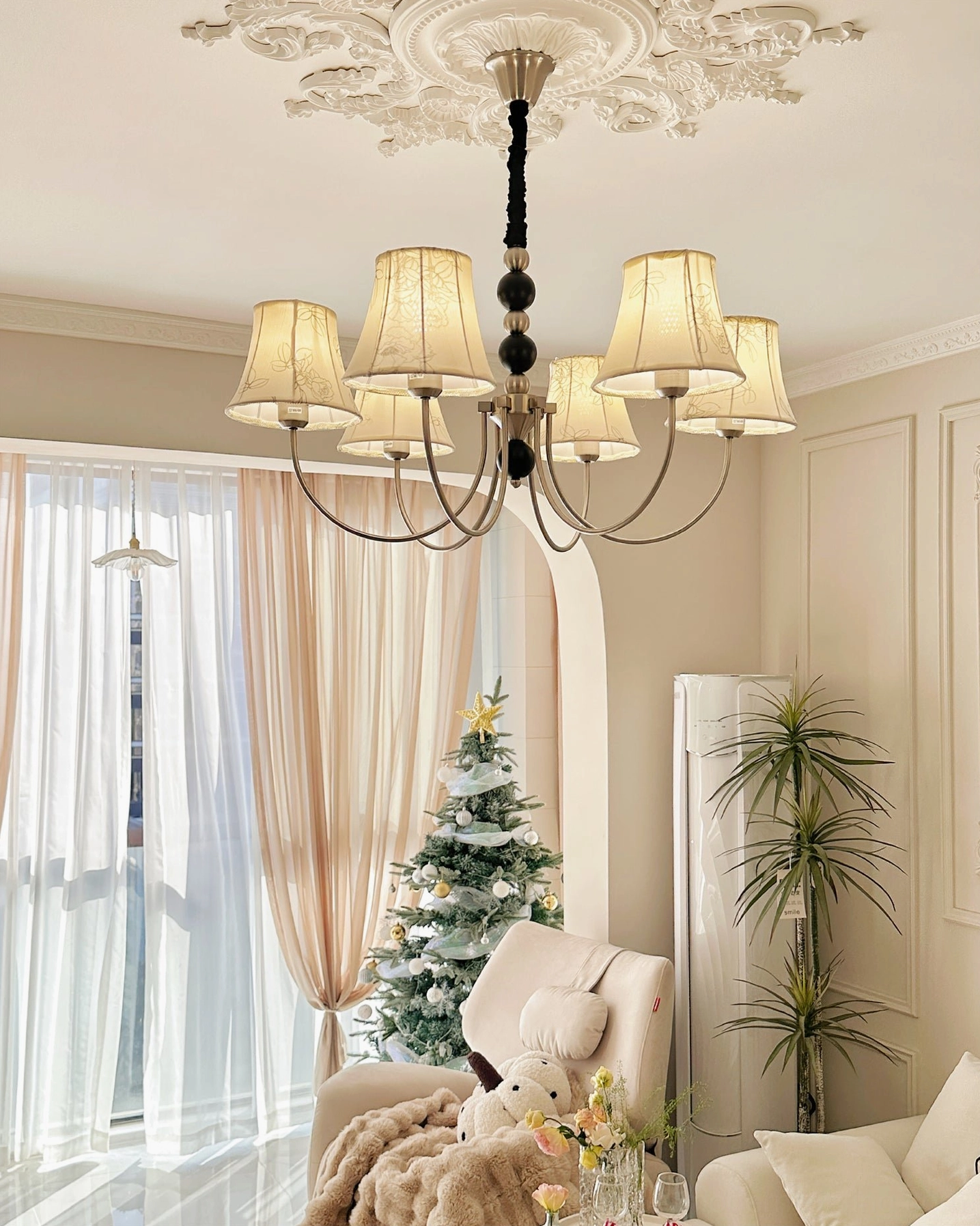 Eight-head fabric chandelier with printed beige shades and silver metal frame in festive holiday setting