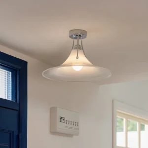 Semi-flush mounting chrome ceiling lamp installed in modern home entryway with navy blue door and contemporary design