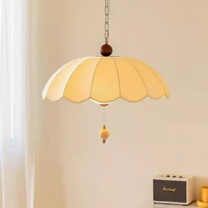 Mid-century modern Oriente pendant light with cream scalloped shade and brass chain detail, three-quarter angle