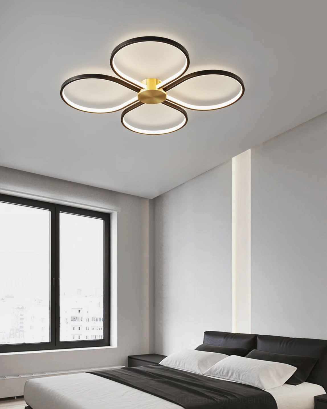 Orion four-leaf clover ceiling lamp with black and brass finish mounted in modern bedroom, soft warm LED lighting over dark bedding