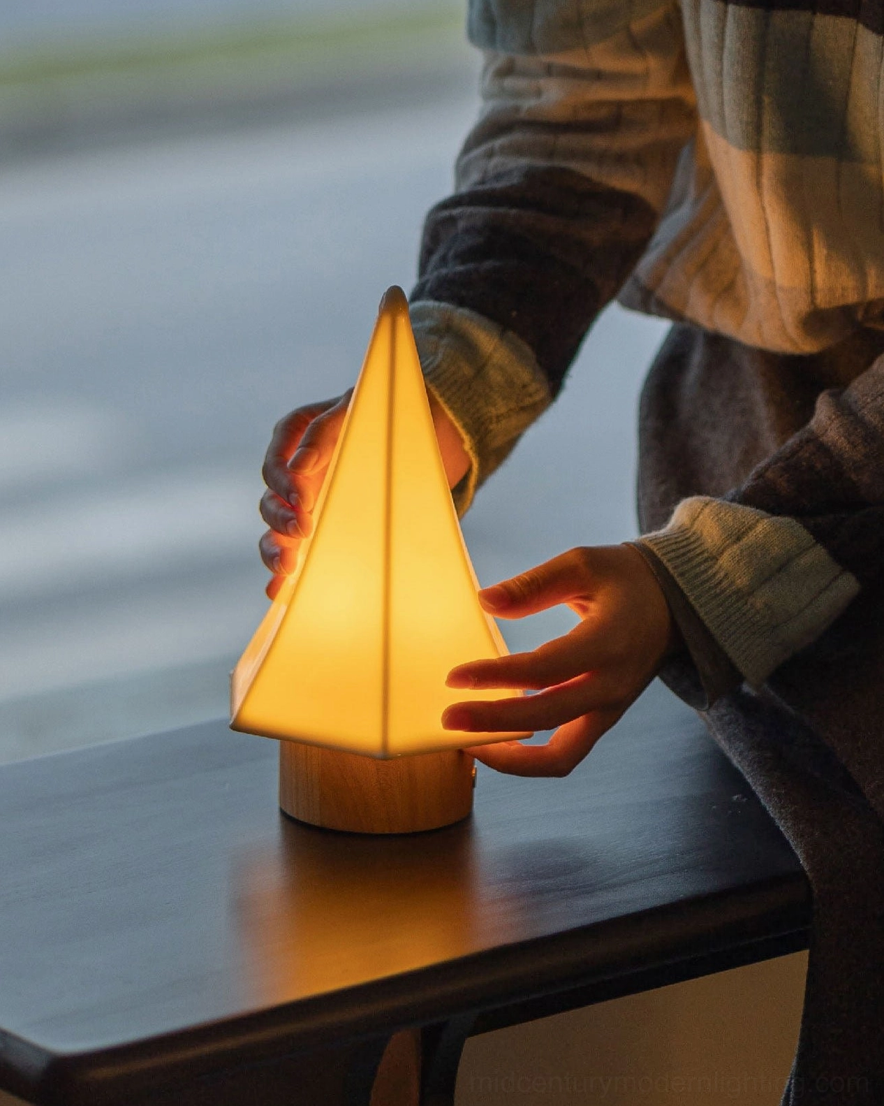 Orlo ceramic table lamp warm glowing light close-up side view dark wooden desk organic modern lighting