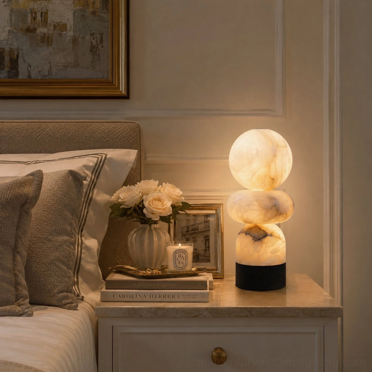 Orso alabaster table lamp glowing on bedroom nightstand with flowers and art