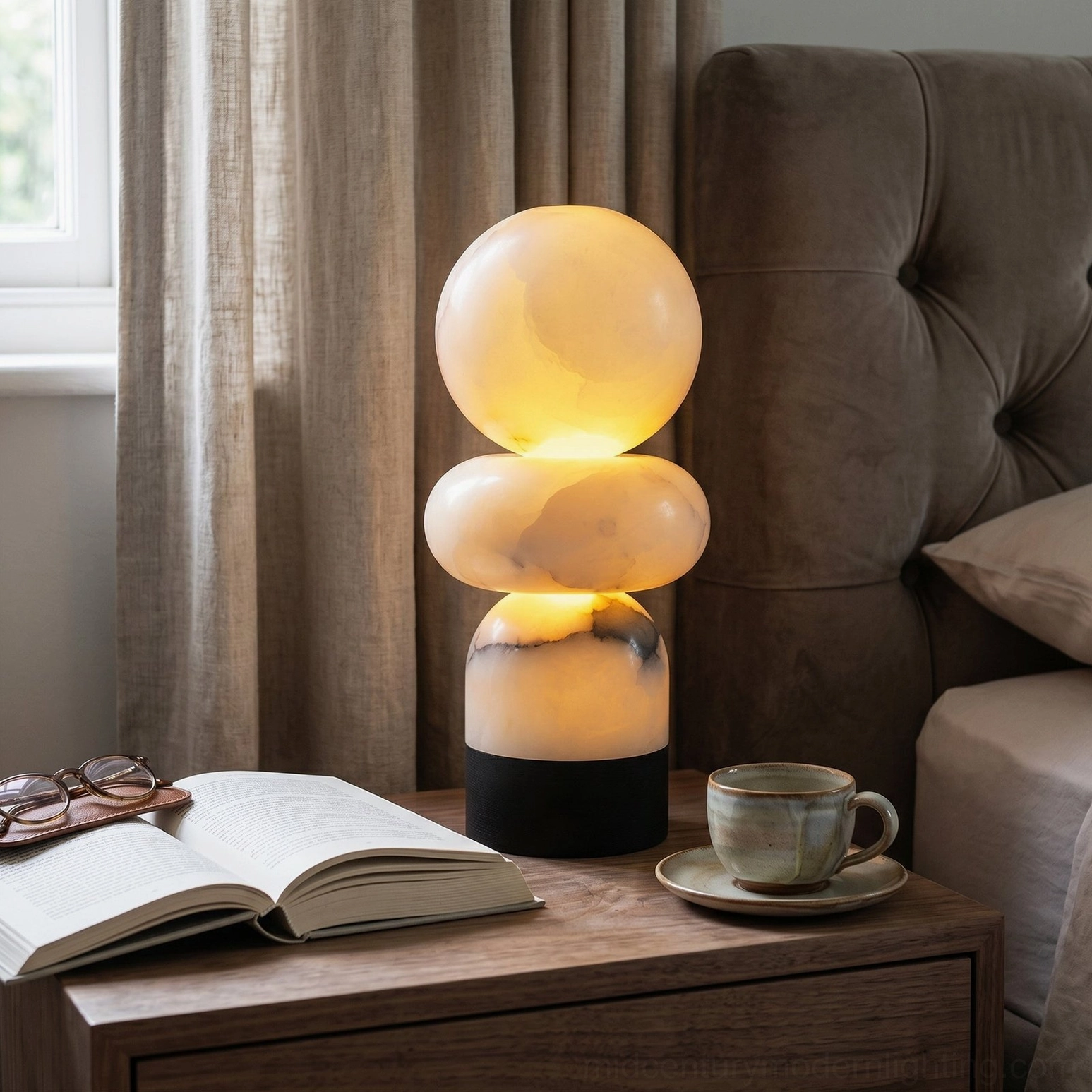 Orso alabaster lamp on bedroom side table with open book and warm lighting