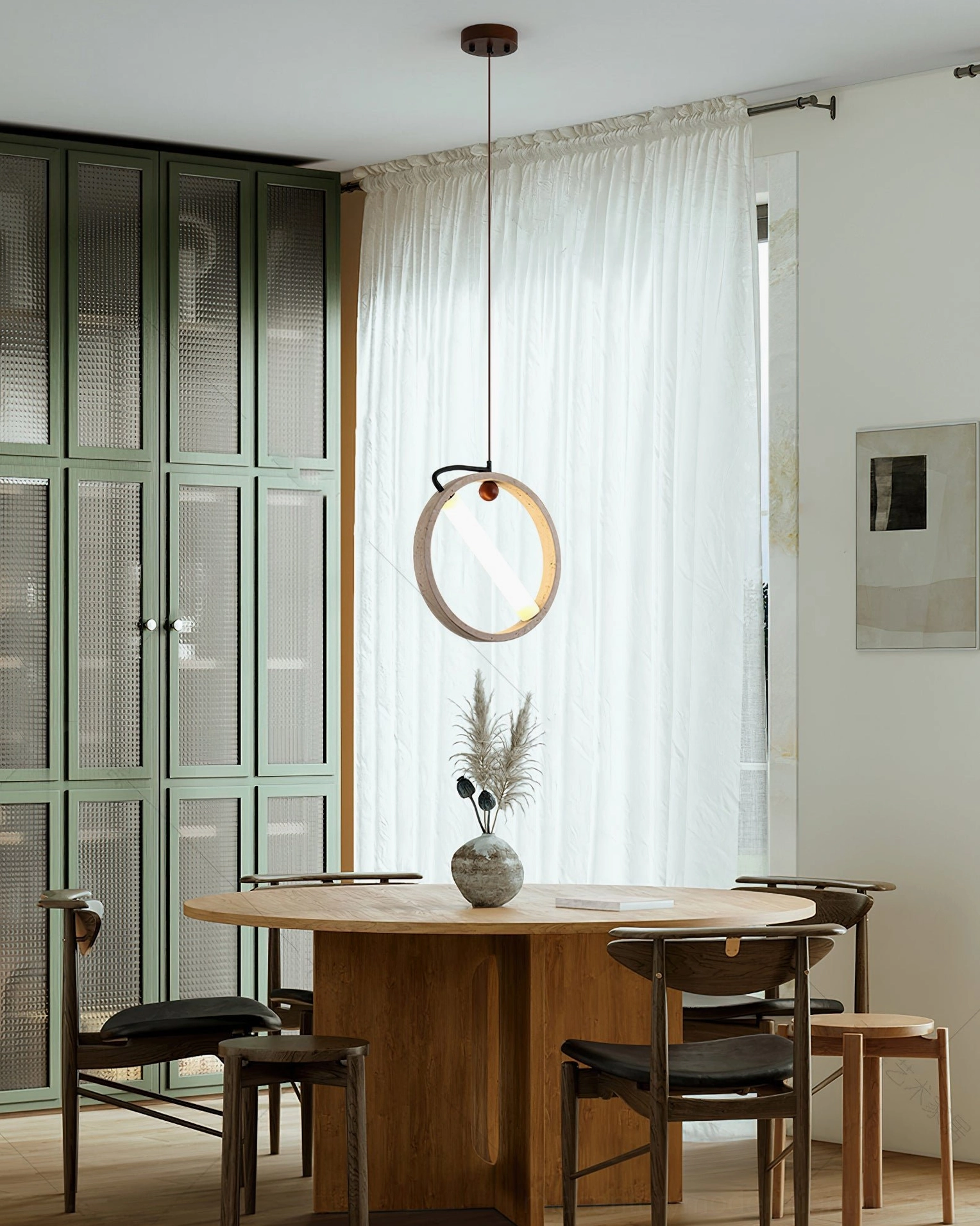 Orvion travertine ring lamp in small dining space with contemporary green glass storage cabinet