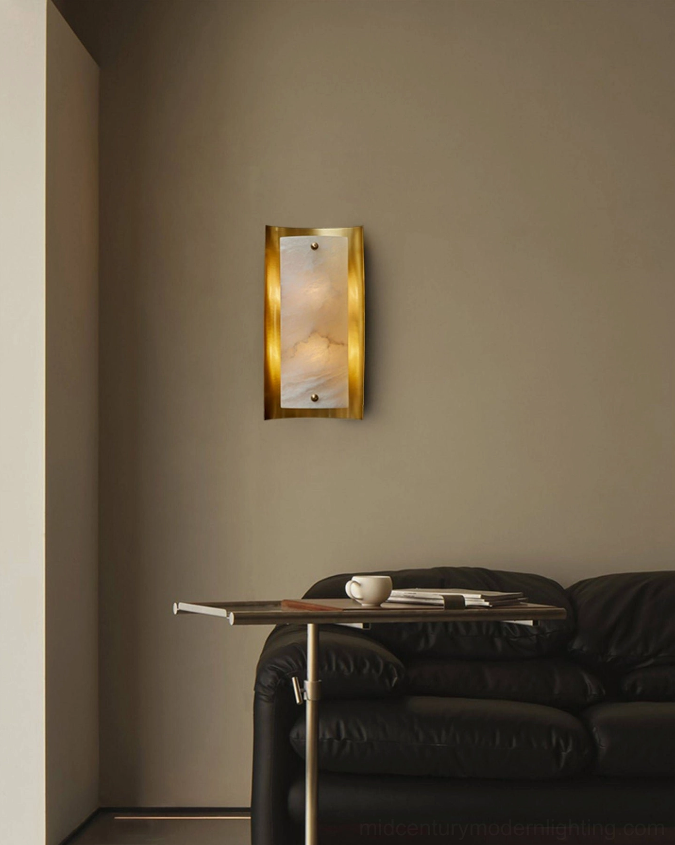 Osman Alabaster Wall Lamp ambient lighting in contemporary living room with leather sofa and minimalist décor