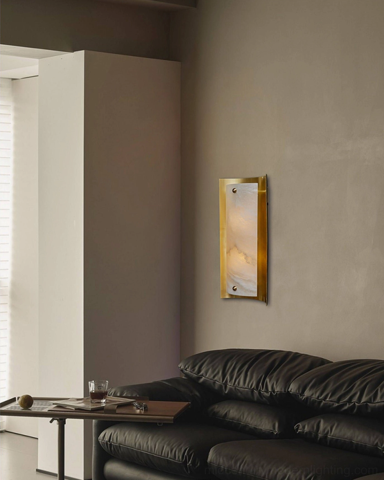 Osman Alabaster Wall Sconce installed in modern minimalist living room interior with warm light glow