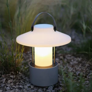 Rechargeable portable outdoor table lamp with matte grey base on garden gravel setting