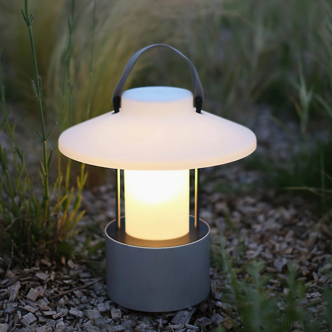 Rechargeable portable outdoor table lamp with matte grey base on garden gravel setting