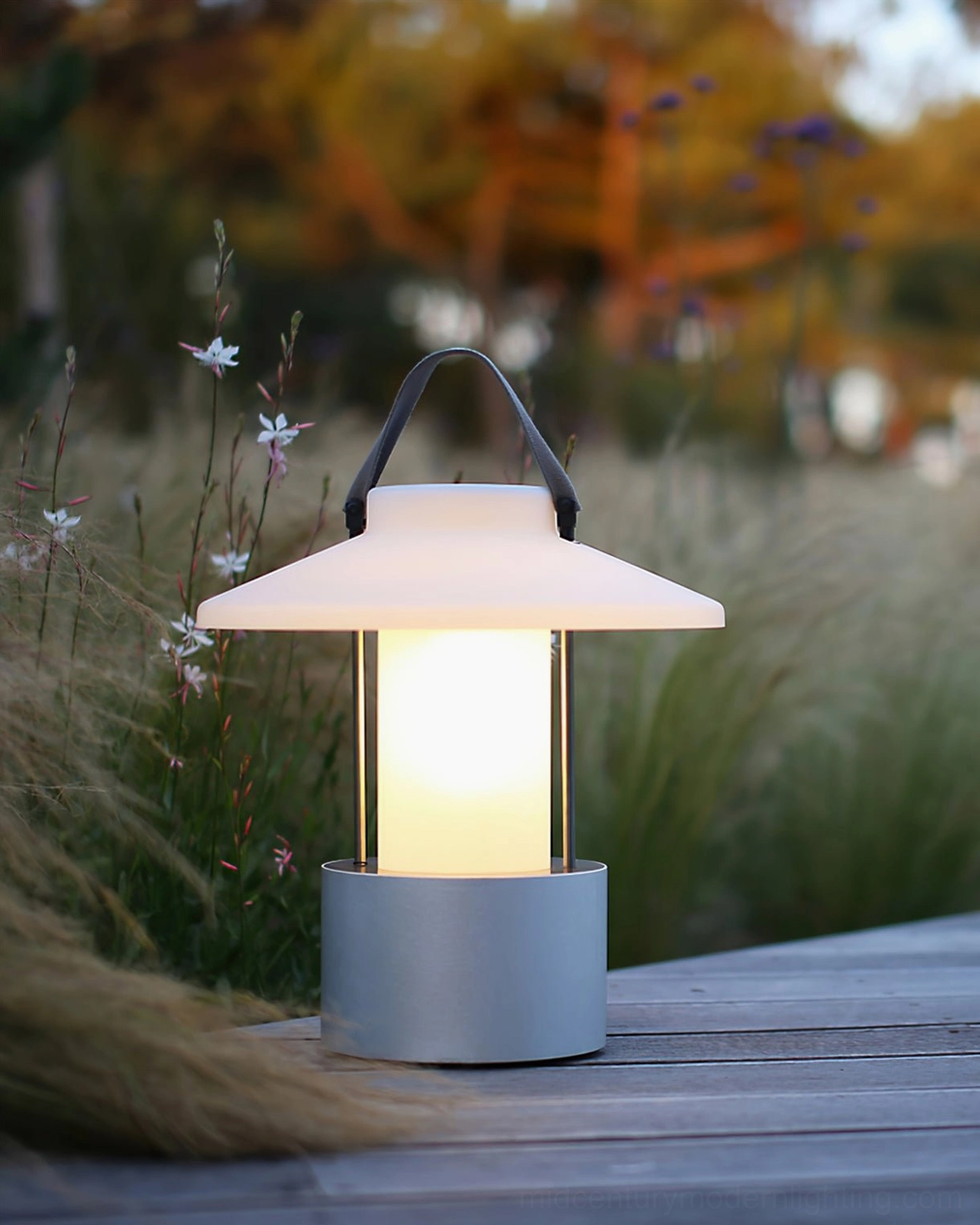 Contemporary cordless table lamp on wooden garden deck with warm illumination
