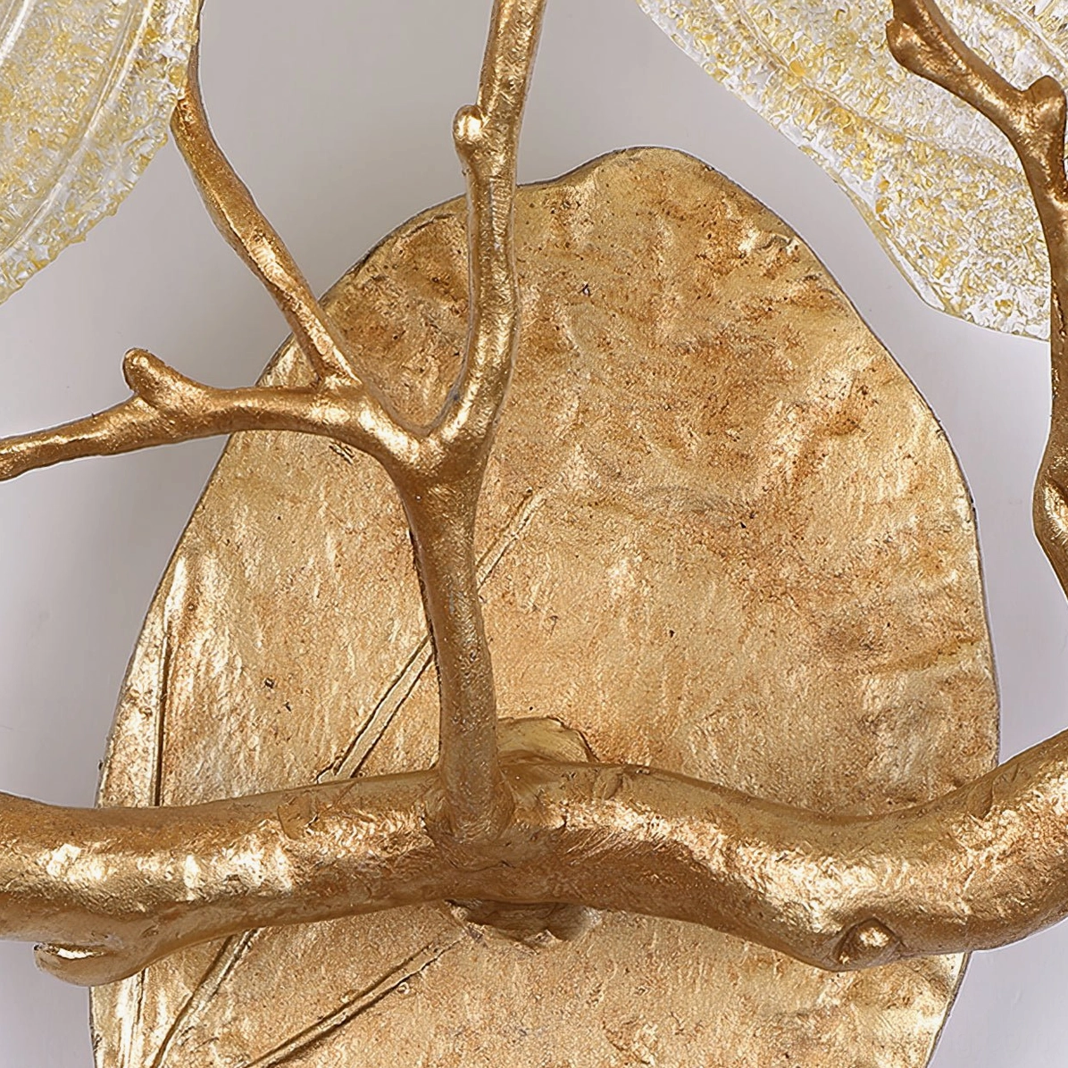 Detailed close-up of hammered brass leaf metalwork and textured brass branch framework
