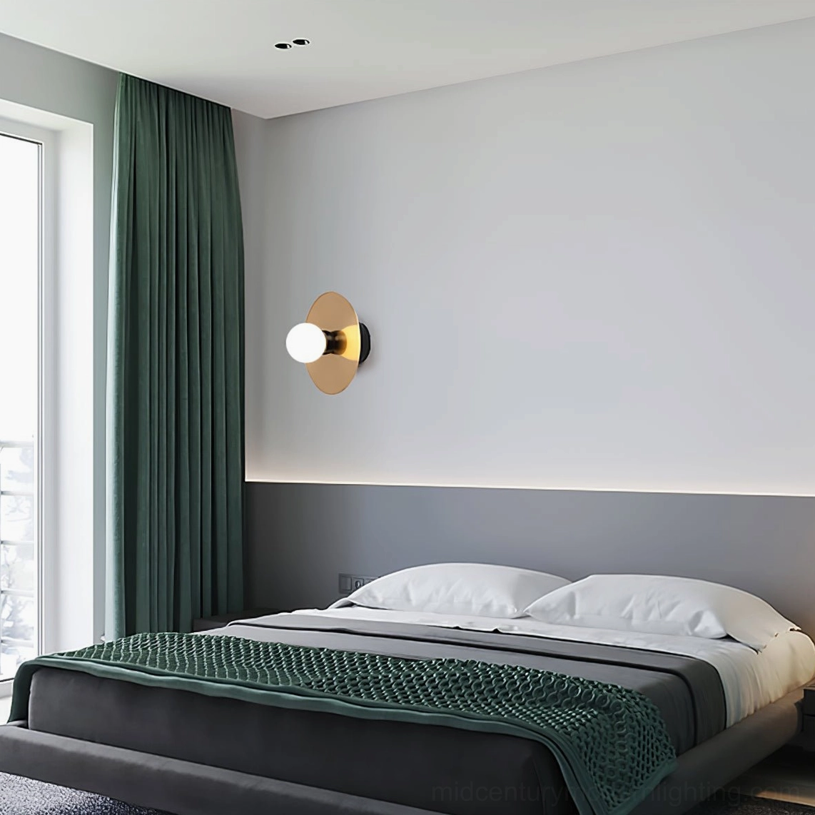 Overhead view of brass disc wall sconce with frosted glass sphere for ambient room lighting