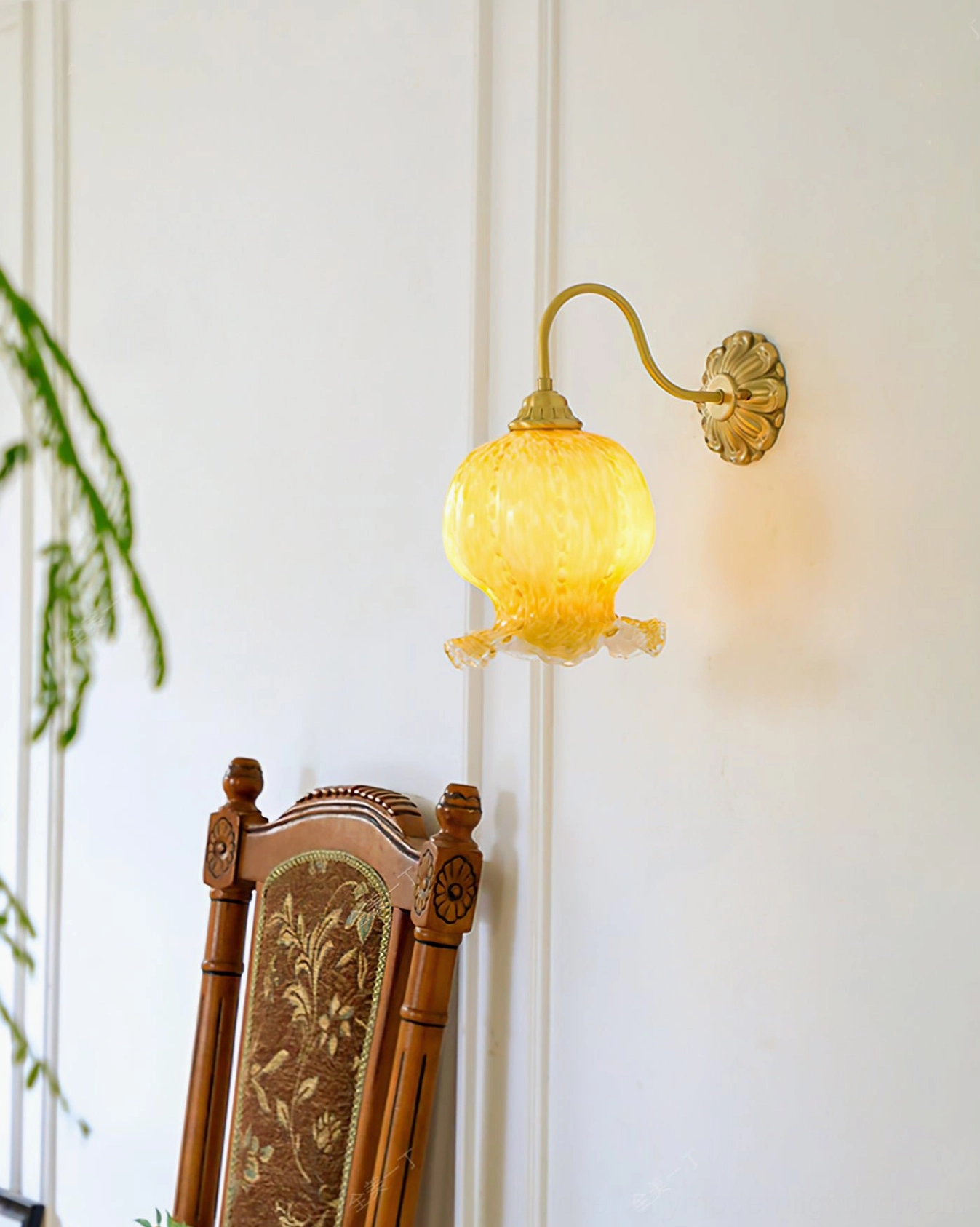 Ozera wall sconce glowing in French vintage interior with warm ambient light and foliage