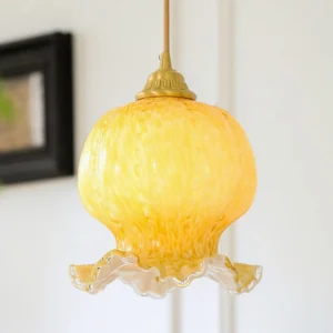 Close-up detail of Ozera pendant light showing textured mottled amber glass and hand-ruffled scalloped edge design