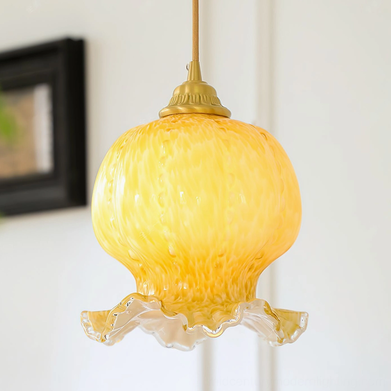 Close-up detail of Ozera pendant light showing textured mottled amber glass and hand-ruffled scalloped edge design