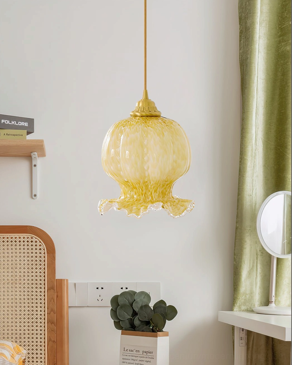 Ozera amber glass pendant light side profile view in cozy bedroom with rattan furniture and plants
