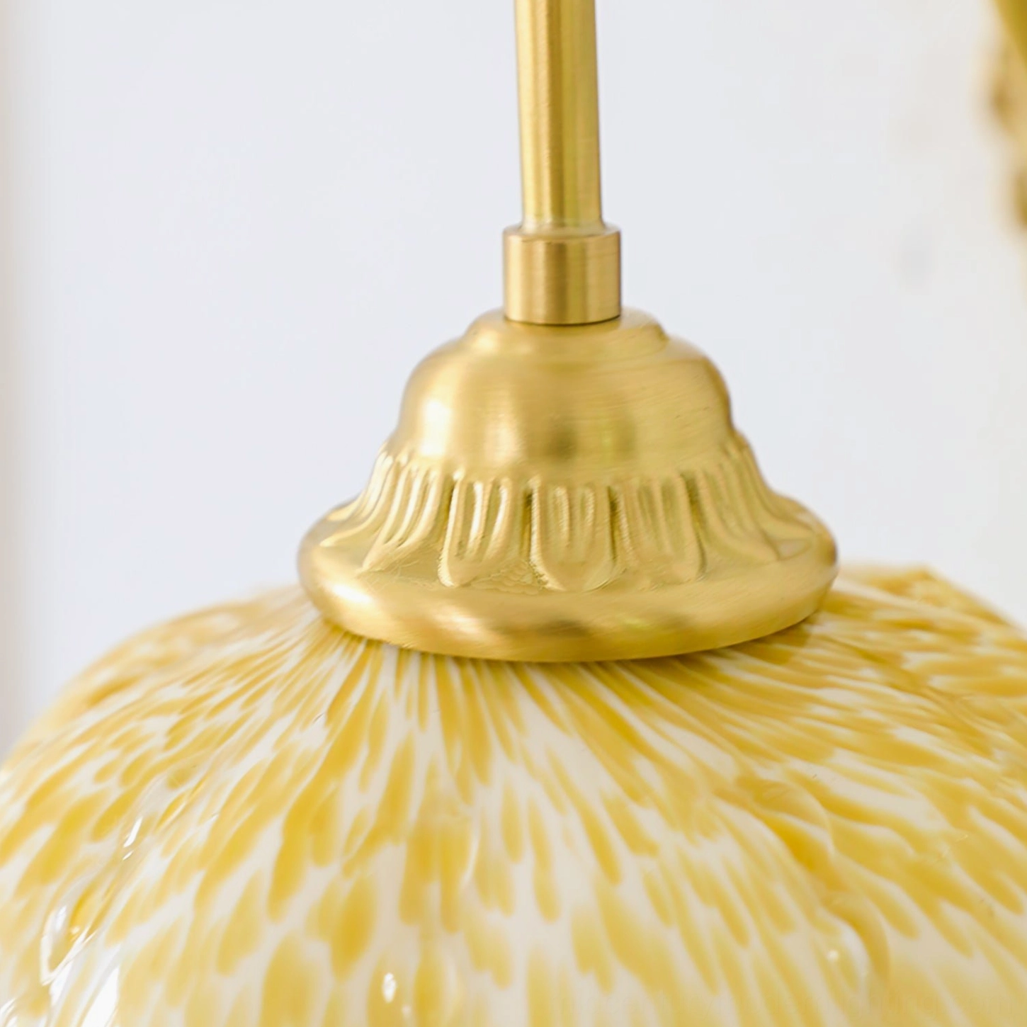 Ozera wall lamp connection detail showing embossed brass finish and marbled glass