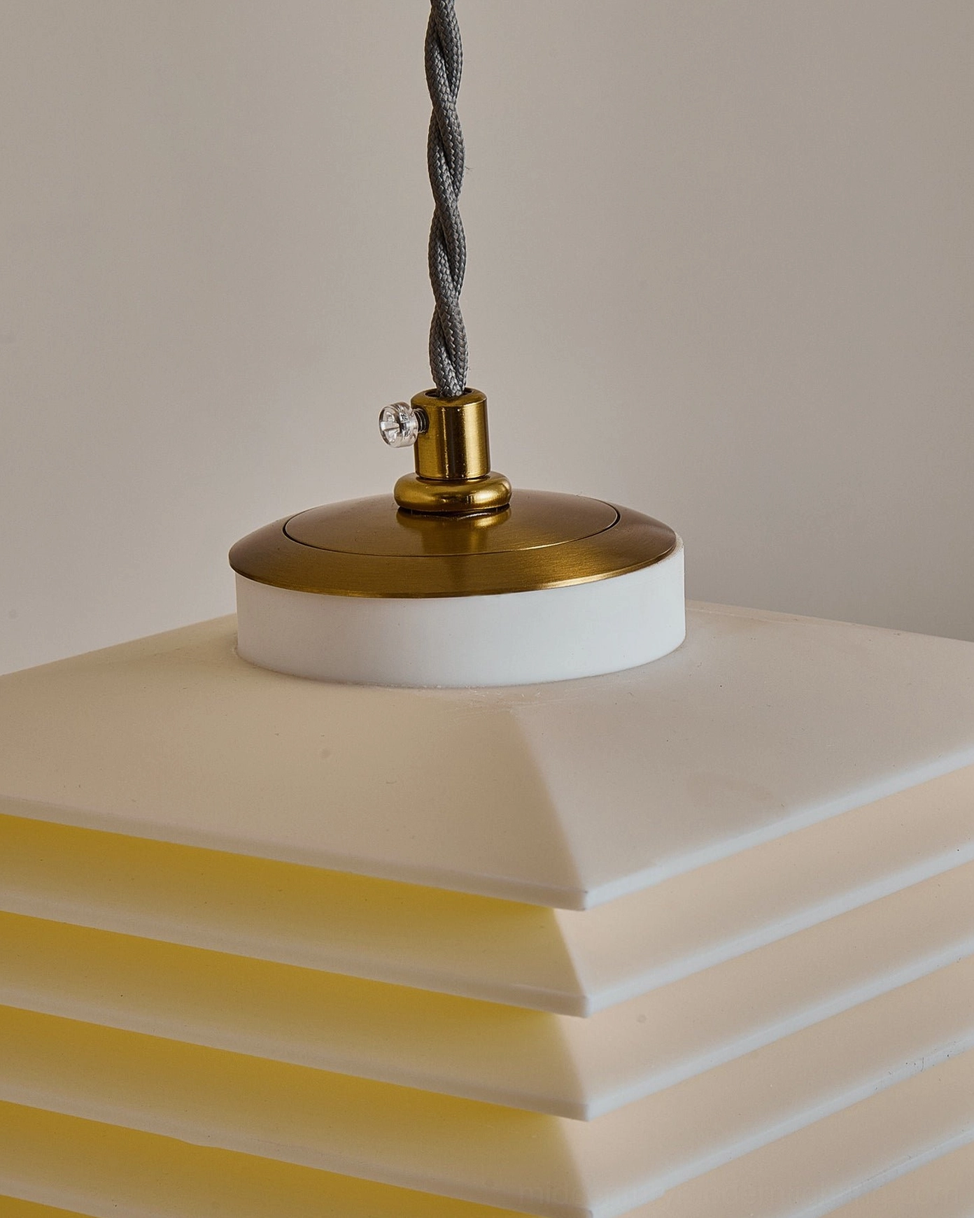 Pagoda layered pendant light installed in contemporary space creating warm architectural focal point