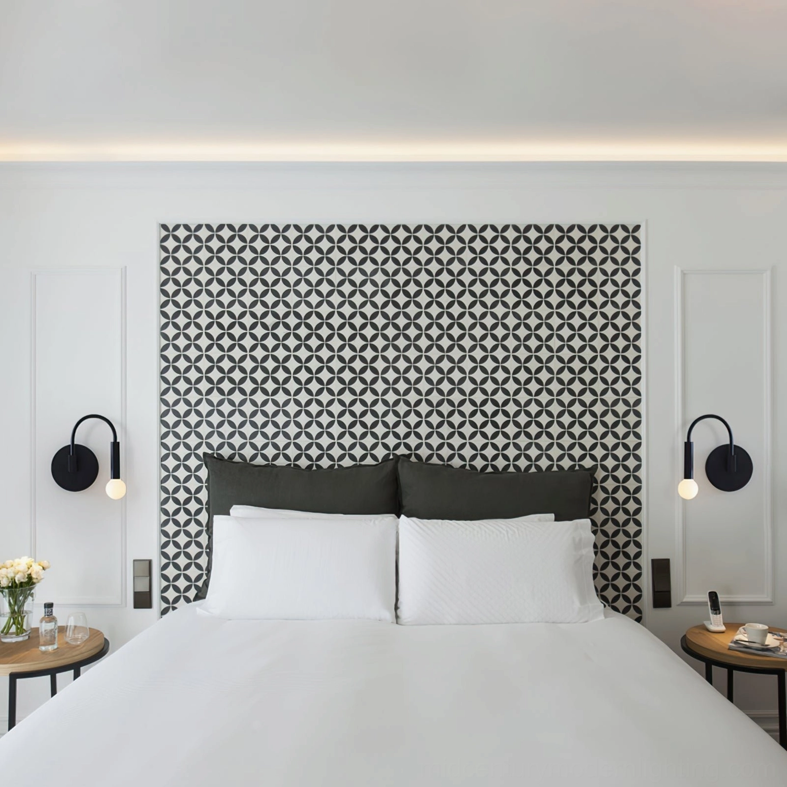 Pair of symmetrically installed arch wall sconces in bedroom with geometric accent wall