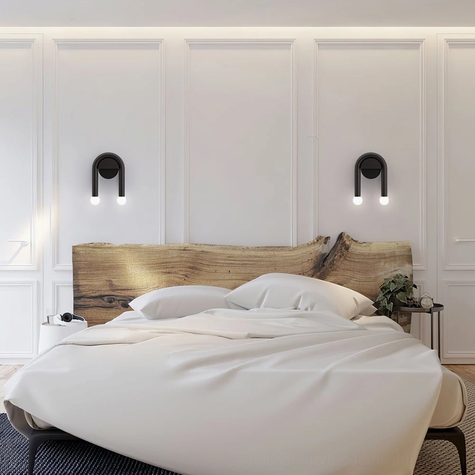 Matching pair of black arched wall sconces installed in minimalist Nordic bedroom interior with king bed