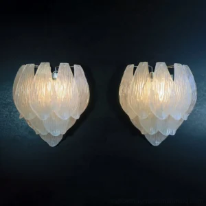 Two frosted petal wall sconces lit with warm ambient light on dark blue backdrop, romantic petal-shaped design