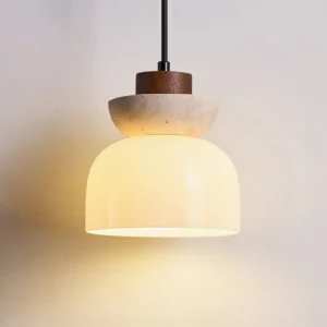 Lit Palak pendant lamp showing warm LED glow through opal white glass shade with travertine and wood top detail close-up