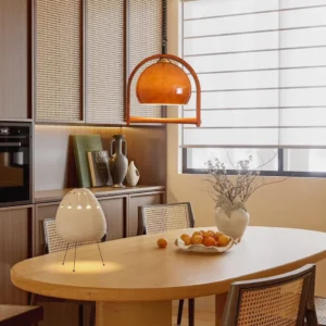 Pallade pendant light in vintage dining room setting with wooden table and rattan chairs, warm amber glow