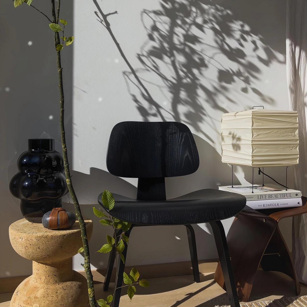 Artistic paper table lamp in sunlit minimalist room with leaf shadow patterns on wall, creating geometric light art and natural ambiance