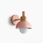 Pastel pink dome wall sconce with natural wood collar, frontal studio view showcasing modern minimalist design
