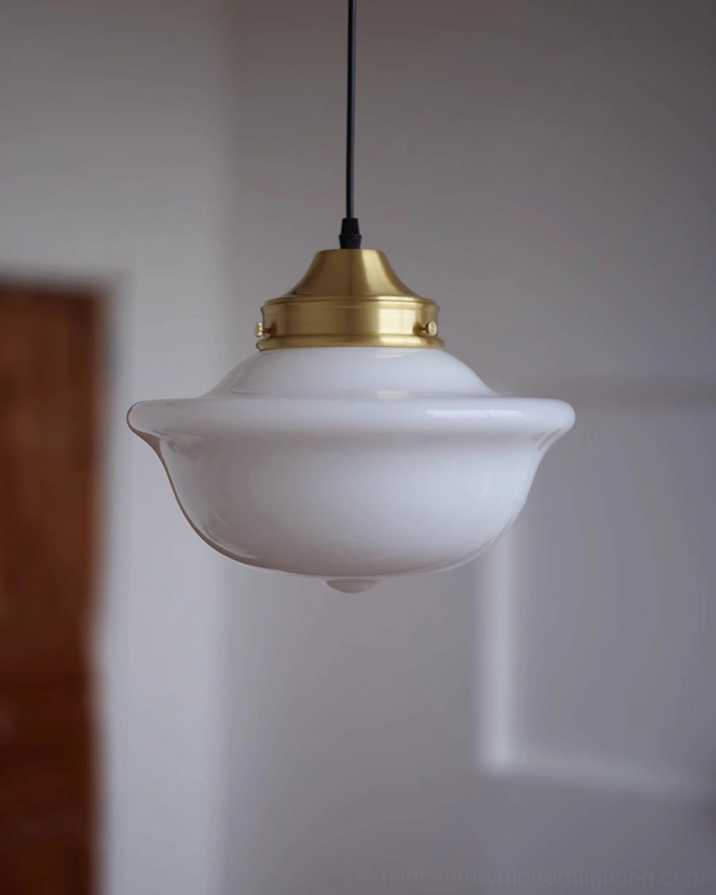 Large Pathson mid-century pendant light with milk glass shade and brass cap, three-quarter front view
