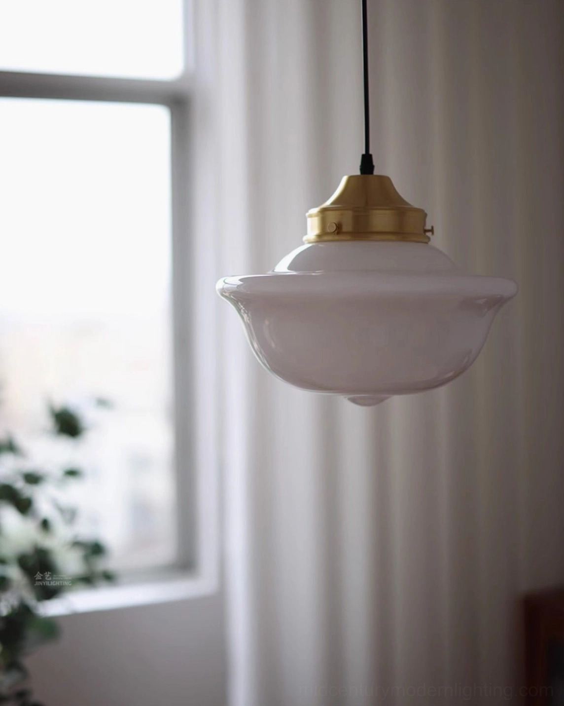 Pathson mid-century pendant light side angle view showing matte white glass and brass hardware in sunlit room