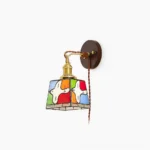 Peace dove stained glass wall lamp with brass hardware and twisted brown cord, showcasing full profile view against white background