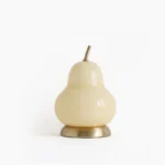Pear-shaped glass cordless table lamp with cream glass and brass base, front studio view on white background