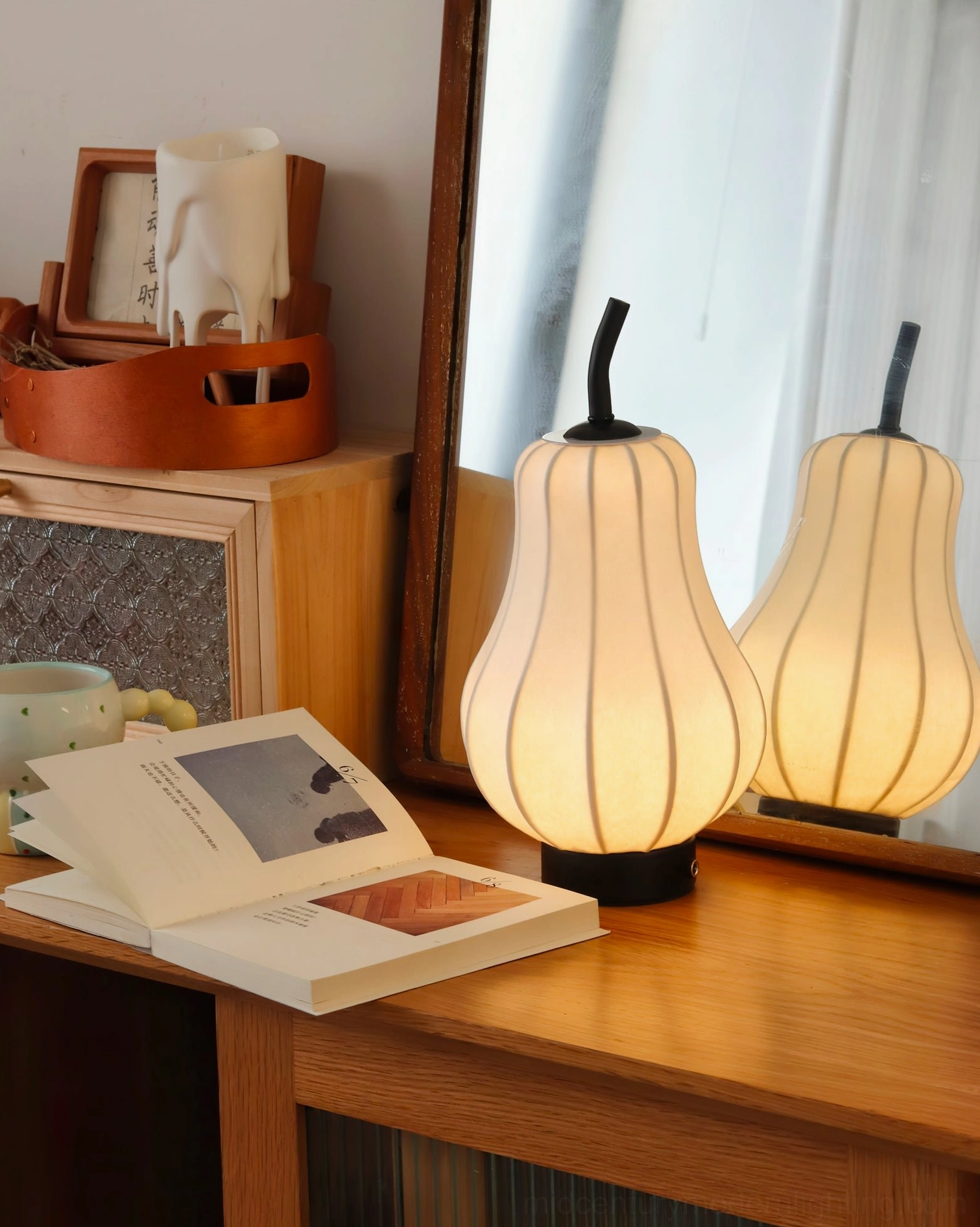 Cordless pear table lamp with warm LED glow on vintage vanity desk, close-up detail shot
