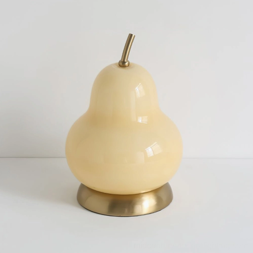 Cream-colored pear glass ambient table lamp with brass base, front-facing studio shot showing sculptural form
