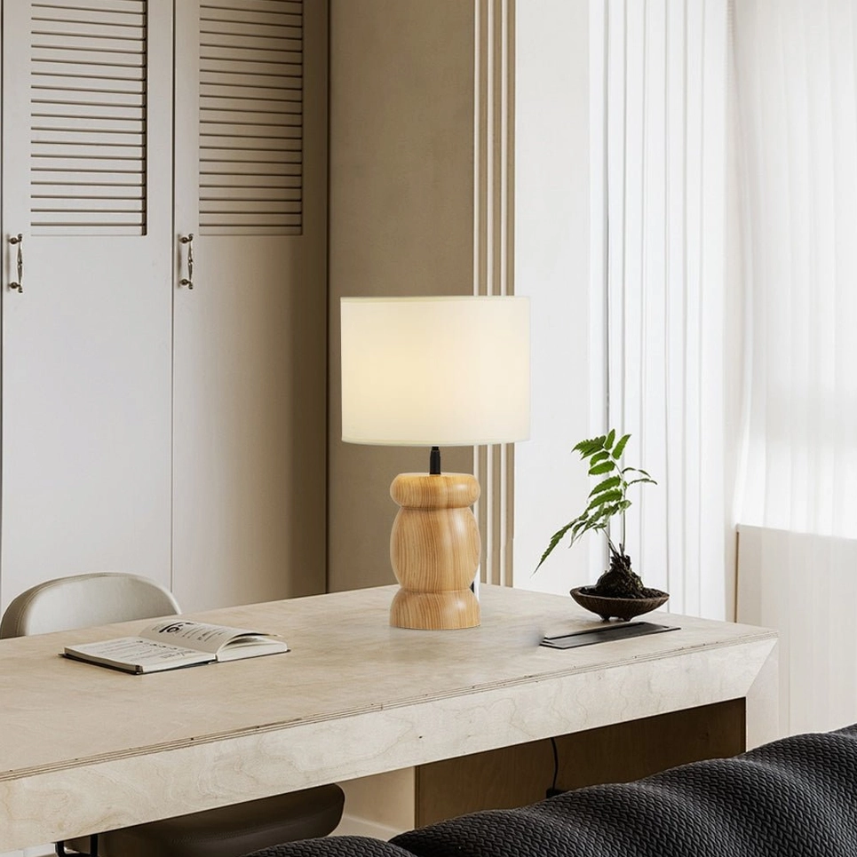 Pebble wood table lamp front facing, natural wood base with soft beige linen-like shade, contemporary interior lighting