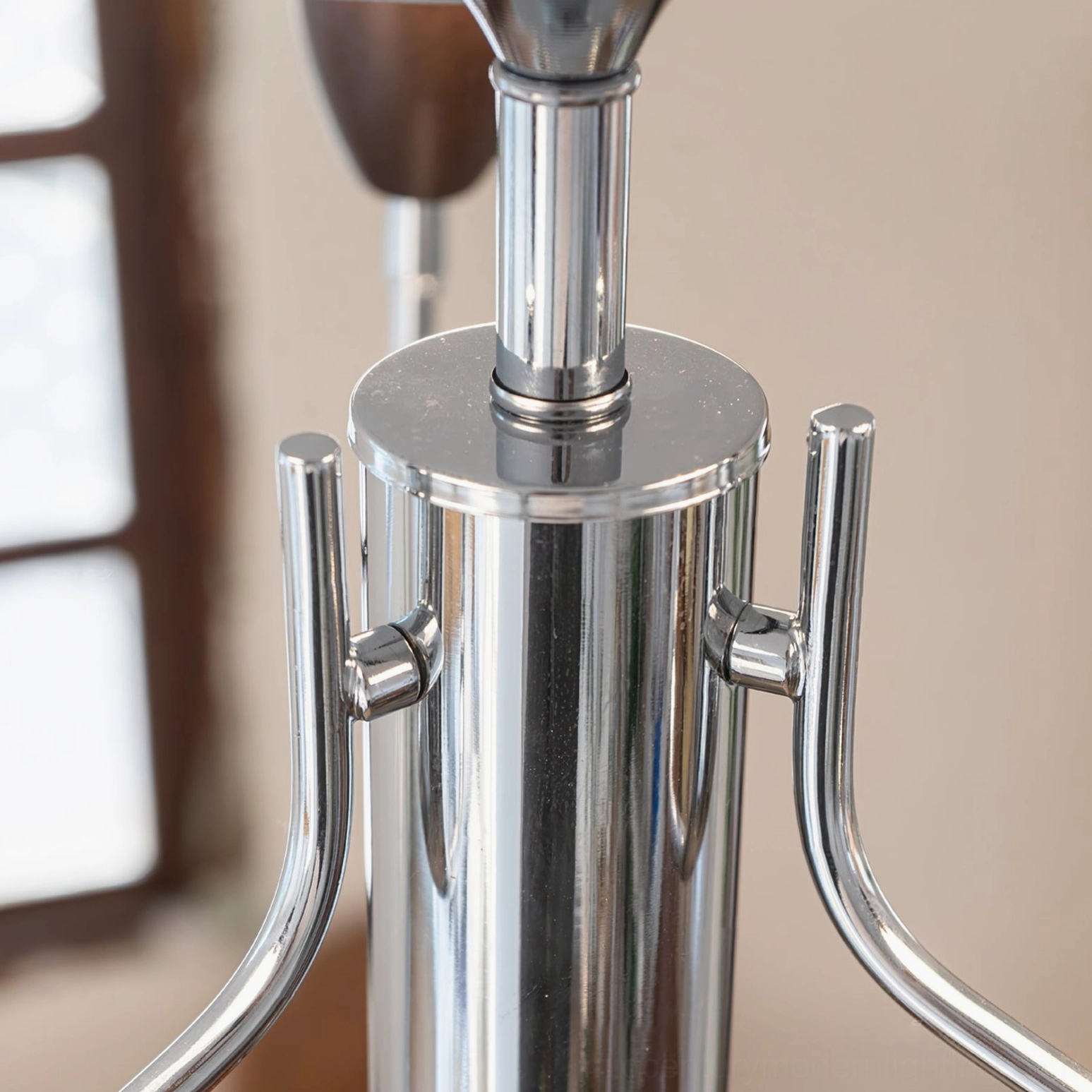 Peggy chandelier chrome arm and base assembly detail, side view showing polished metal finish and construction quality