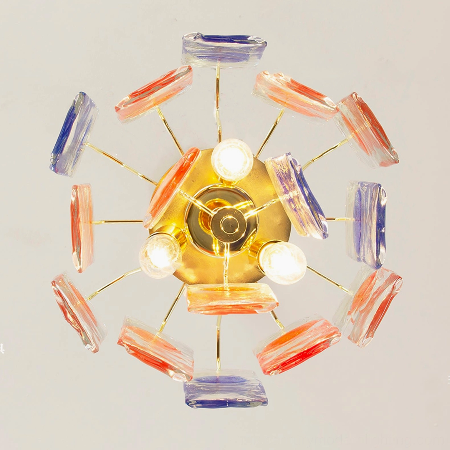 Bottom view of mid-century art glass pendant lamp showing radial gold metal frame with flat colored glass pieces