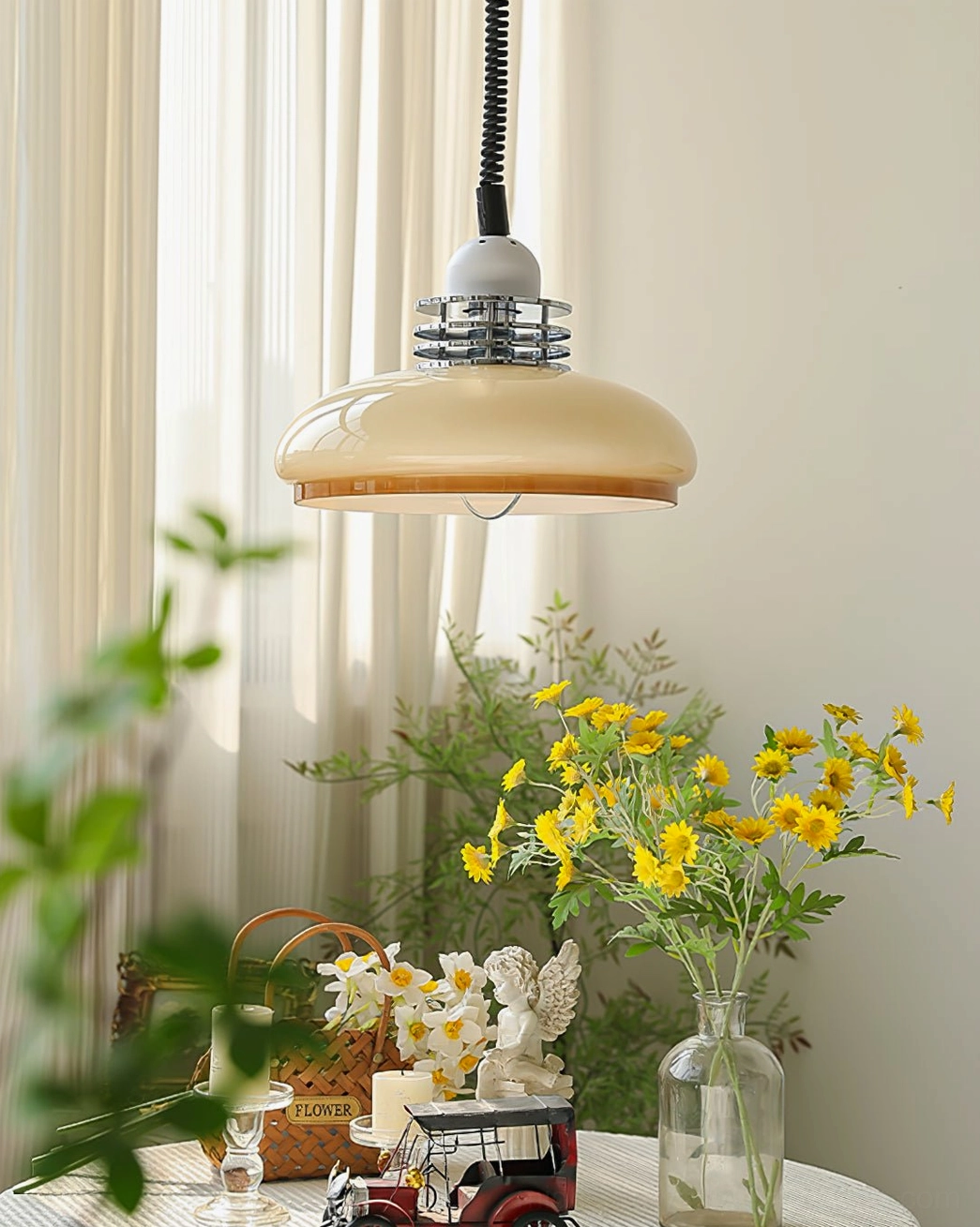 Distant side view of beige orange gradient pendant lamp in dining area with table setting and soft natural light from sheer curtains
