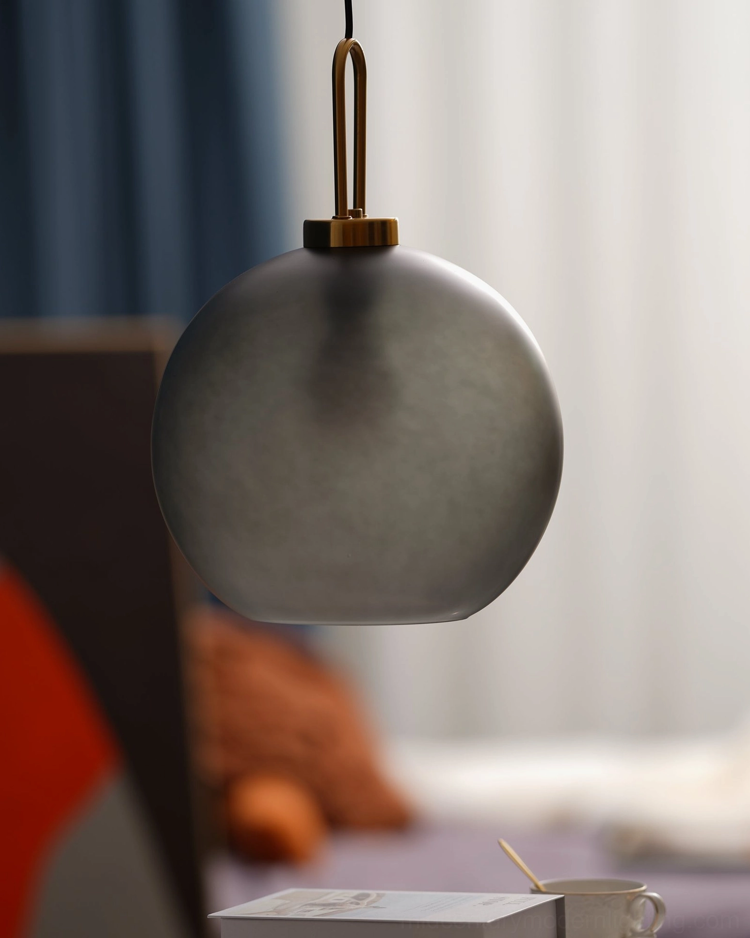 Smoked glass pendant light fixture detail shot showing brass hardware and frosted gray glass craftsmanship