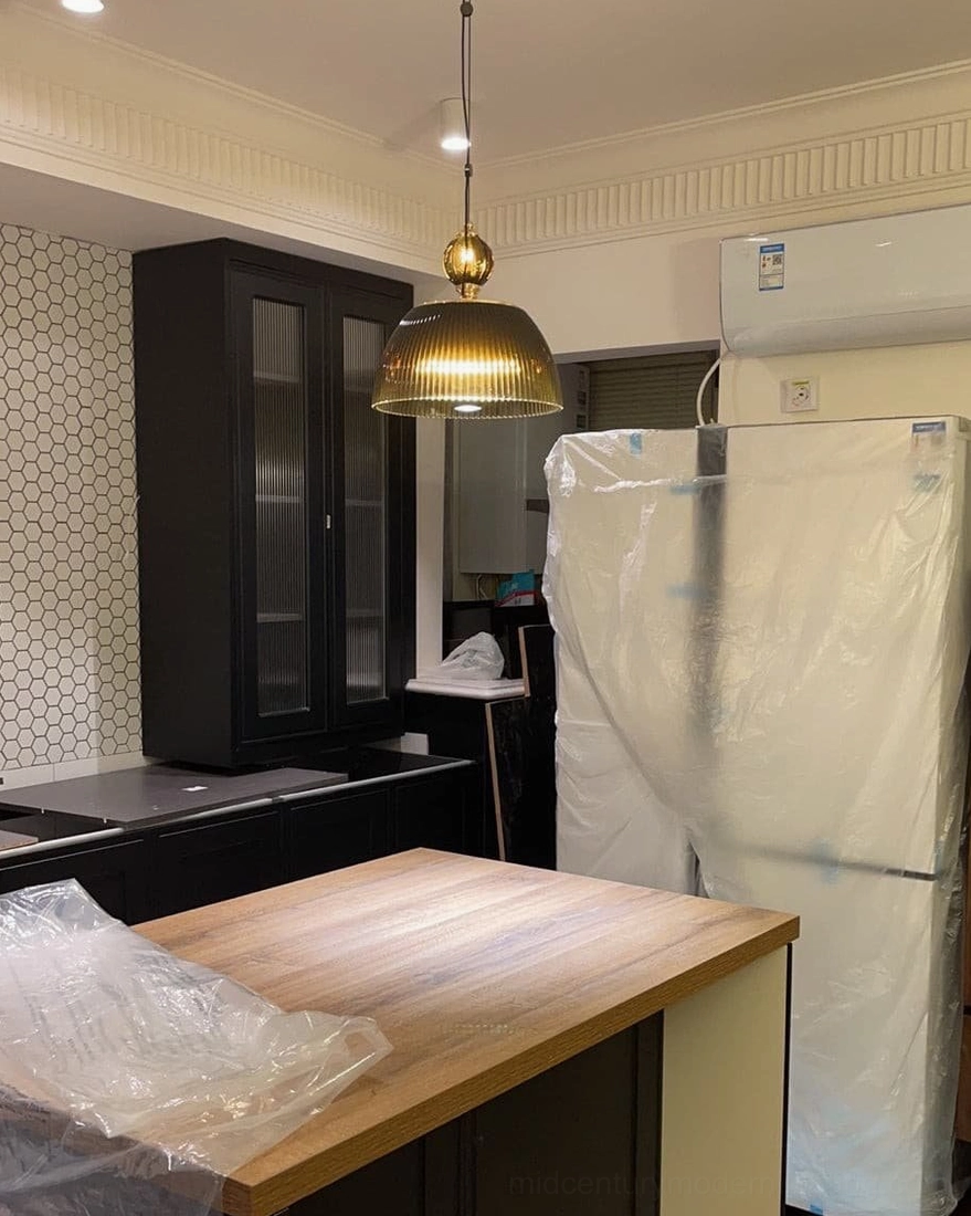Vintage ribbed glass pendant light hanging above wooden kitchen counter - warm ambient lighting in contemporary kitchen