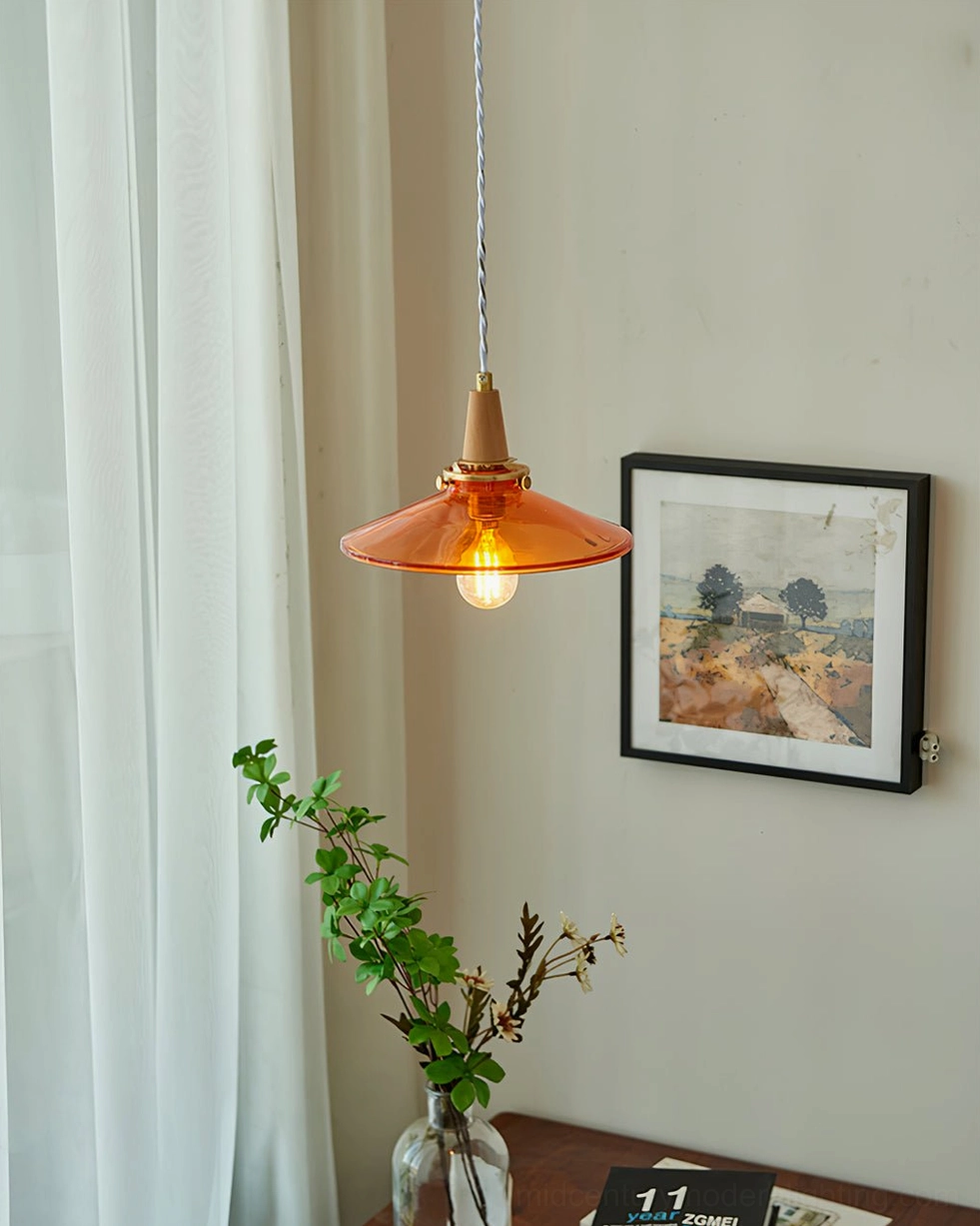 Amber glass pendant light in sunlit room with sheer curtains, potted plants, and framed wall art - natural daylight ambiance