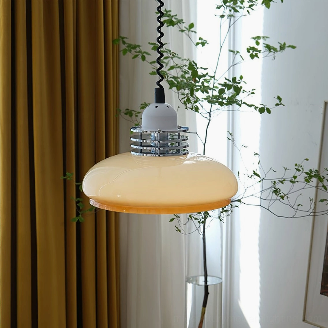 Full side profile of beige orange gradient glass pendant hanging in sunlit room with mustard curtain and natural daylight