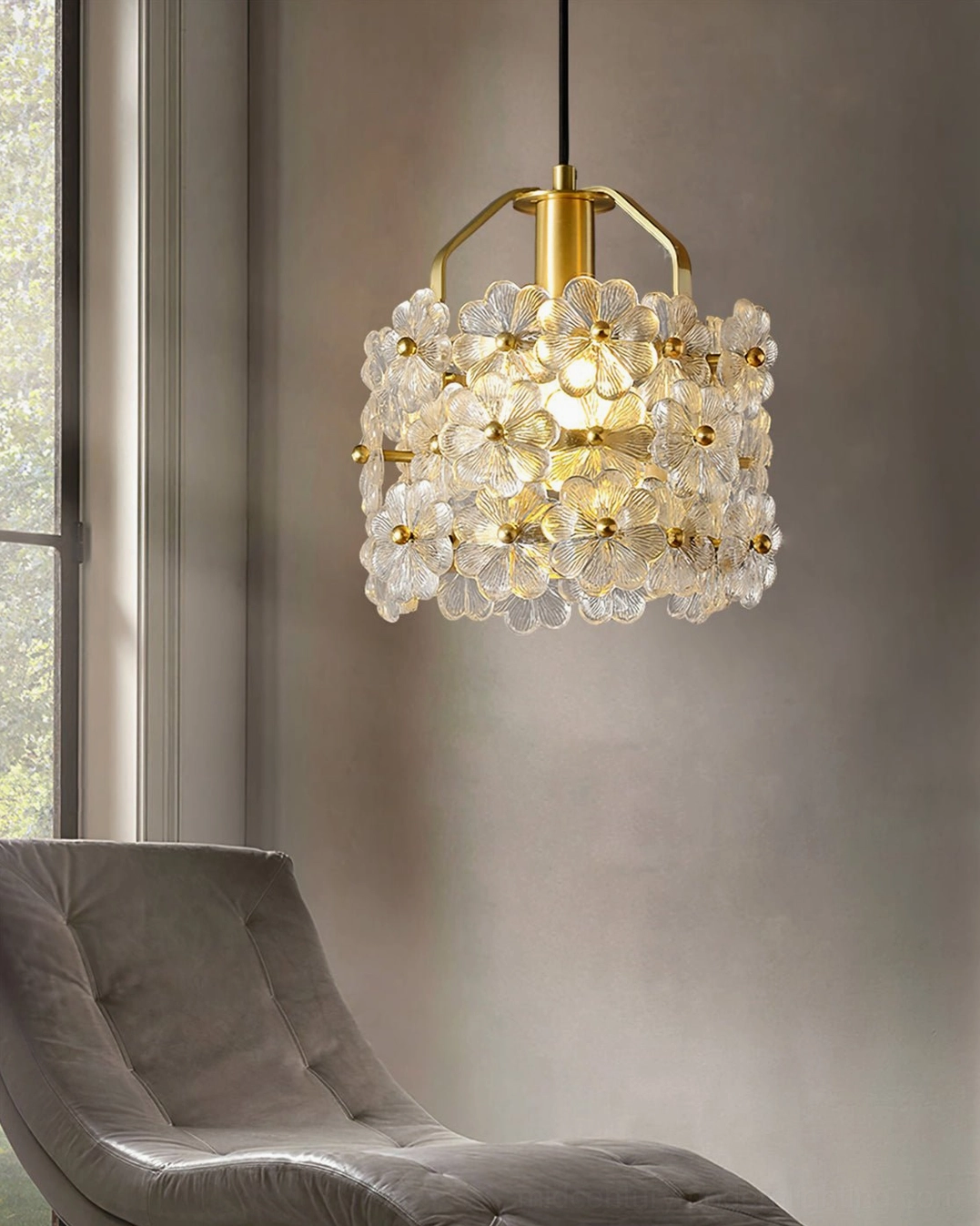 Brass and glass floral pendant beside window light in lounge with upholstered seating arrangement