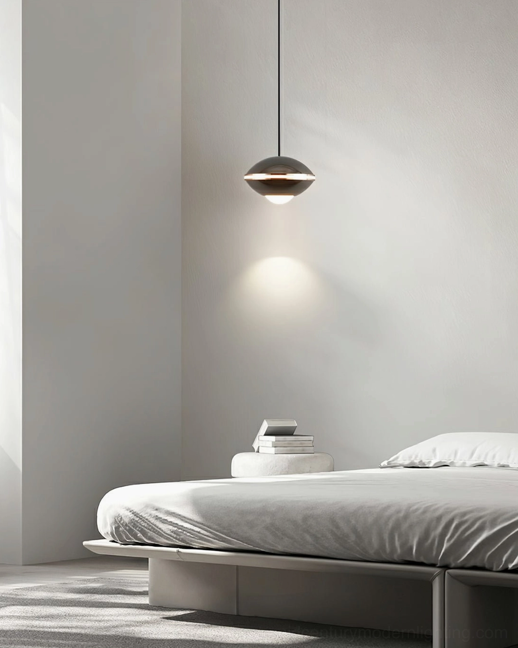 Dark metallic disc pendant light beside platform bed, warm ambient bedroom illumination