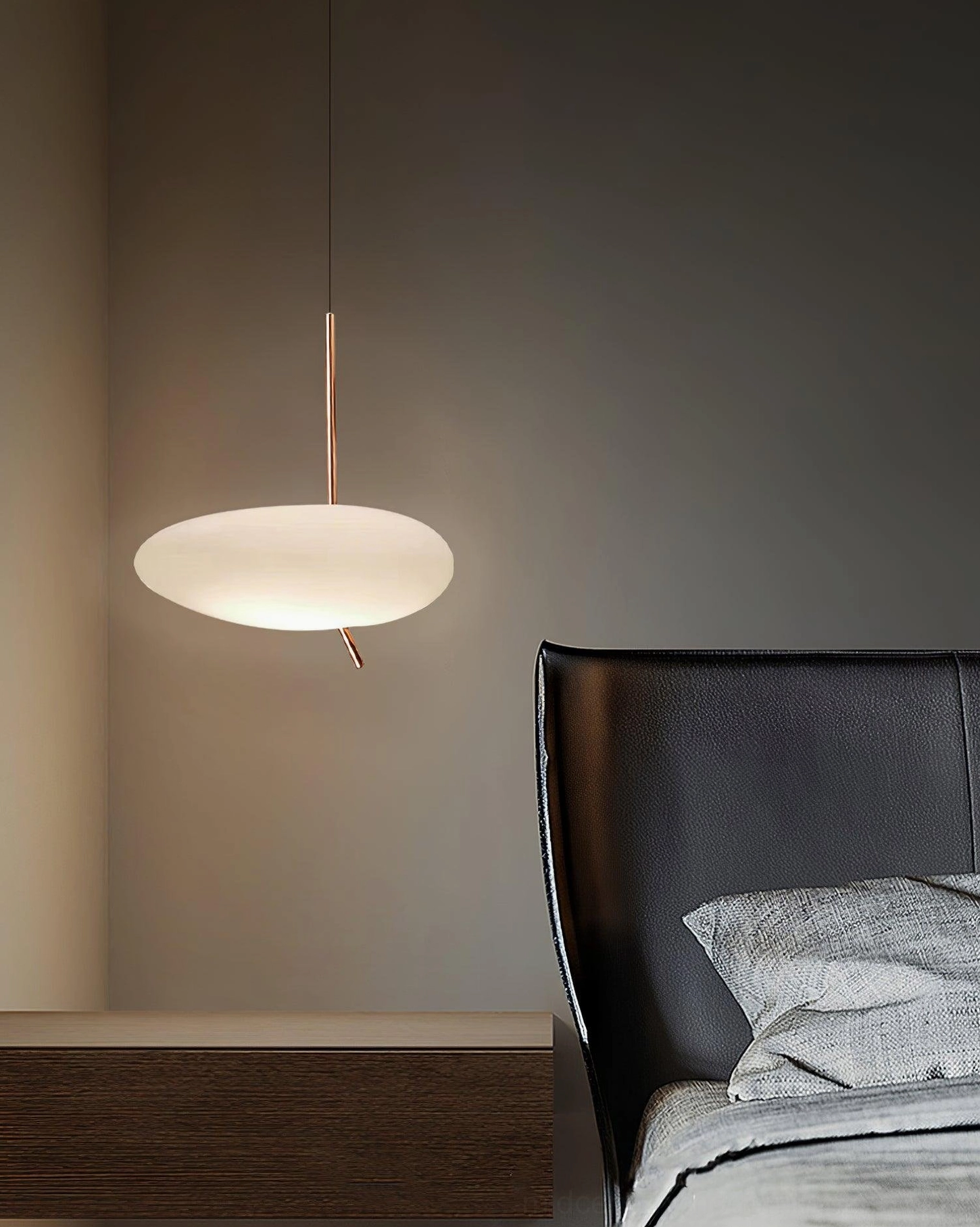 Pendant light in modern bedroom with leather bed frame, warm ambient lighting from pebbles shade