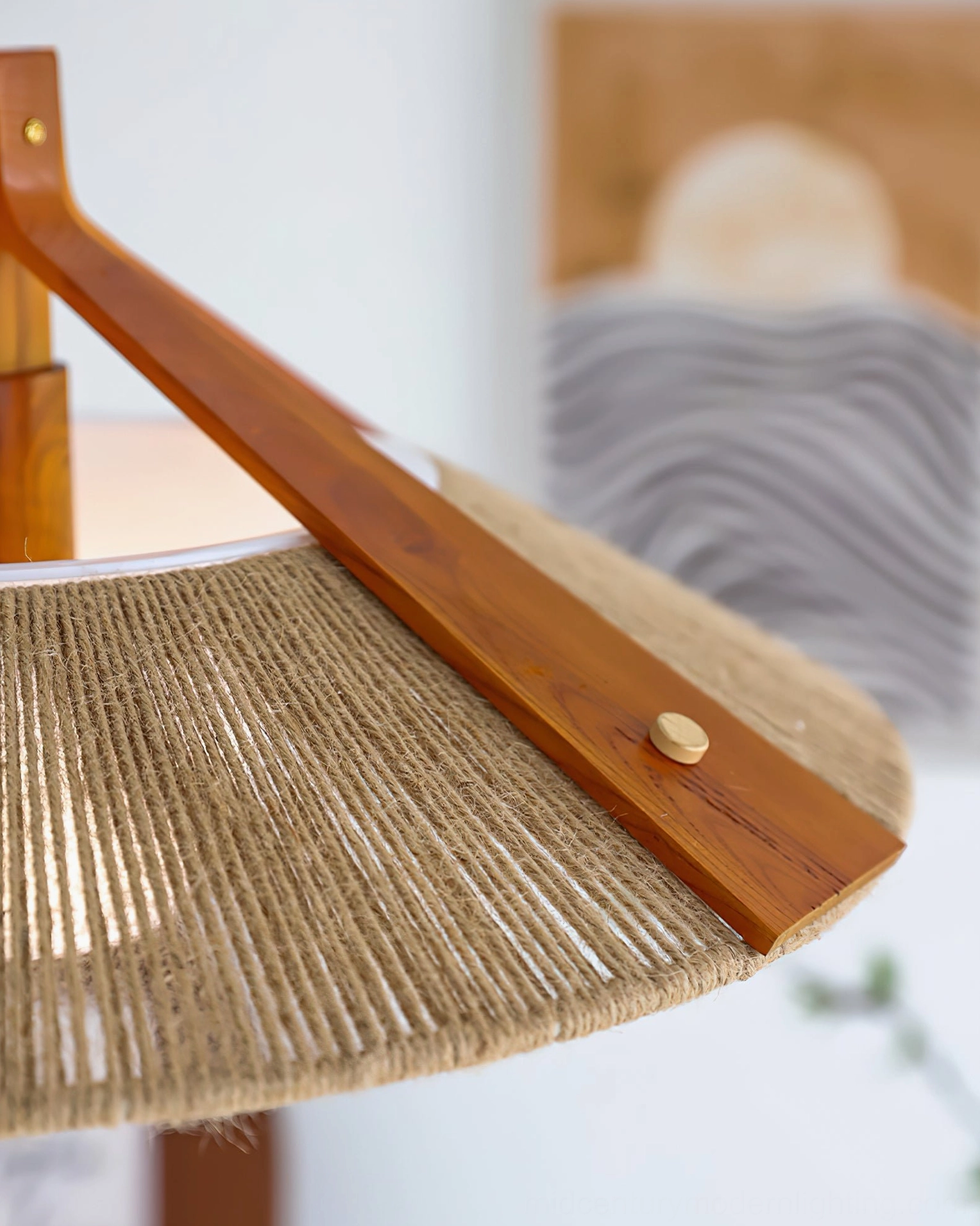 Close-up detail of Millier pendant showing brass hardware, solid wood arm construction, and natural jute raffia shade edge craftsmanship