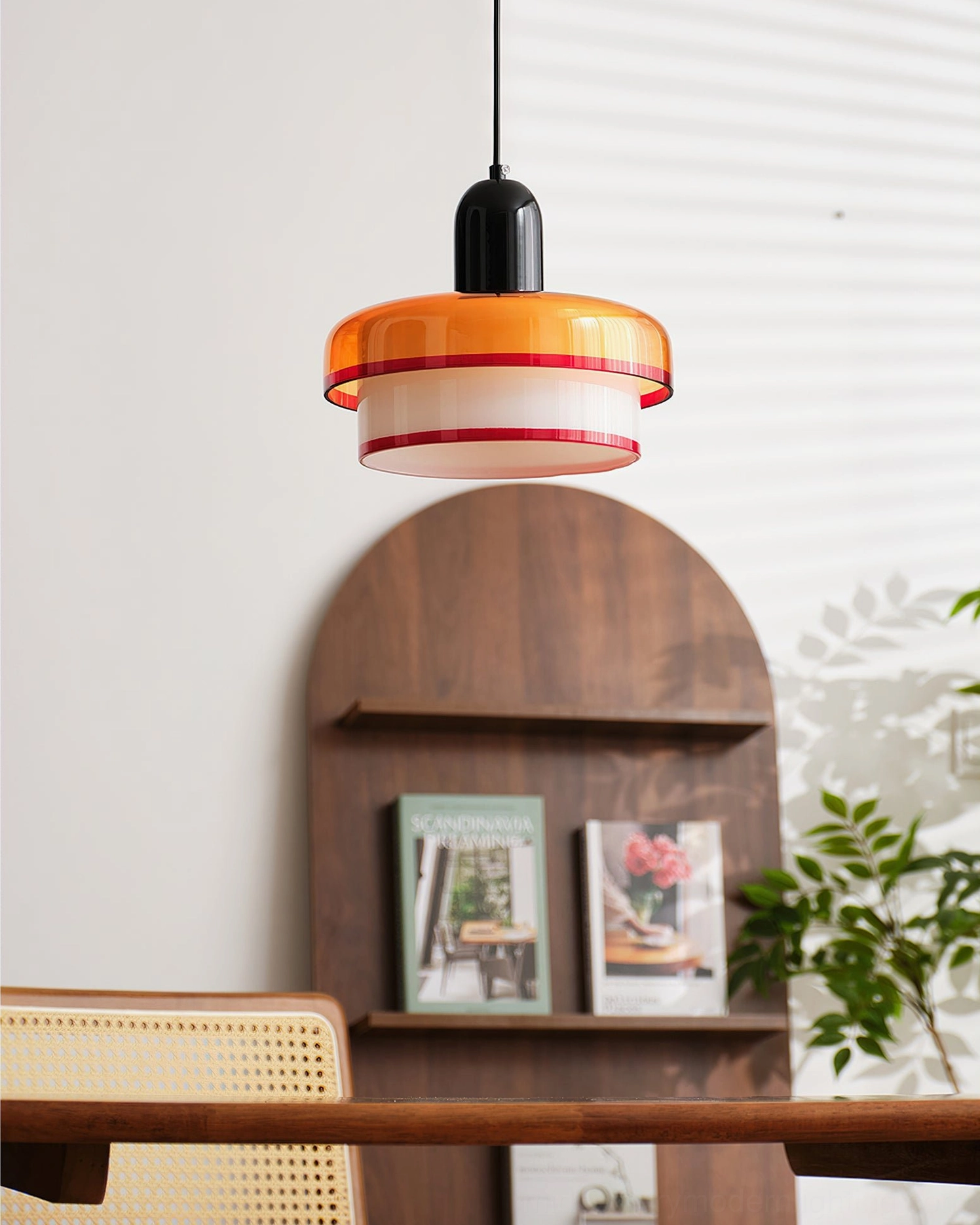 Layered glass pendant light over wooden dining table in mid-century modern home interior