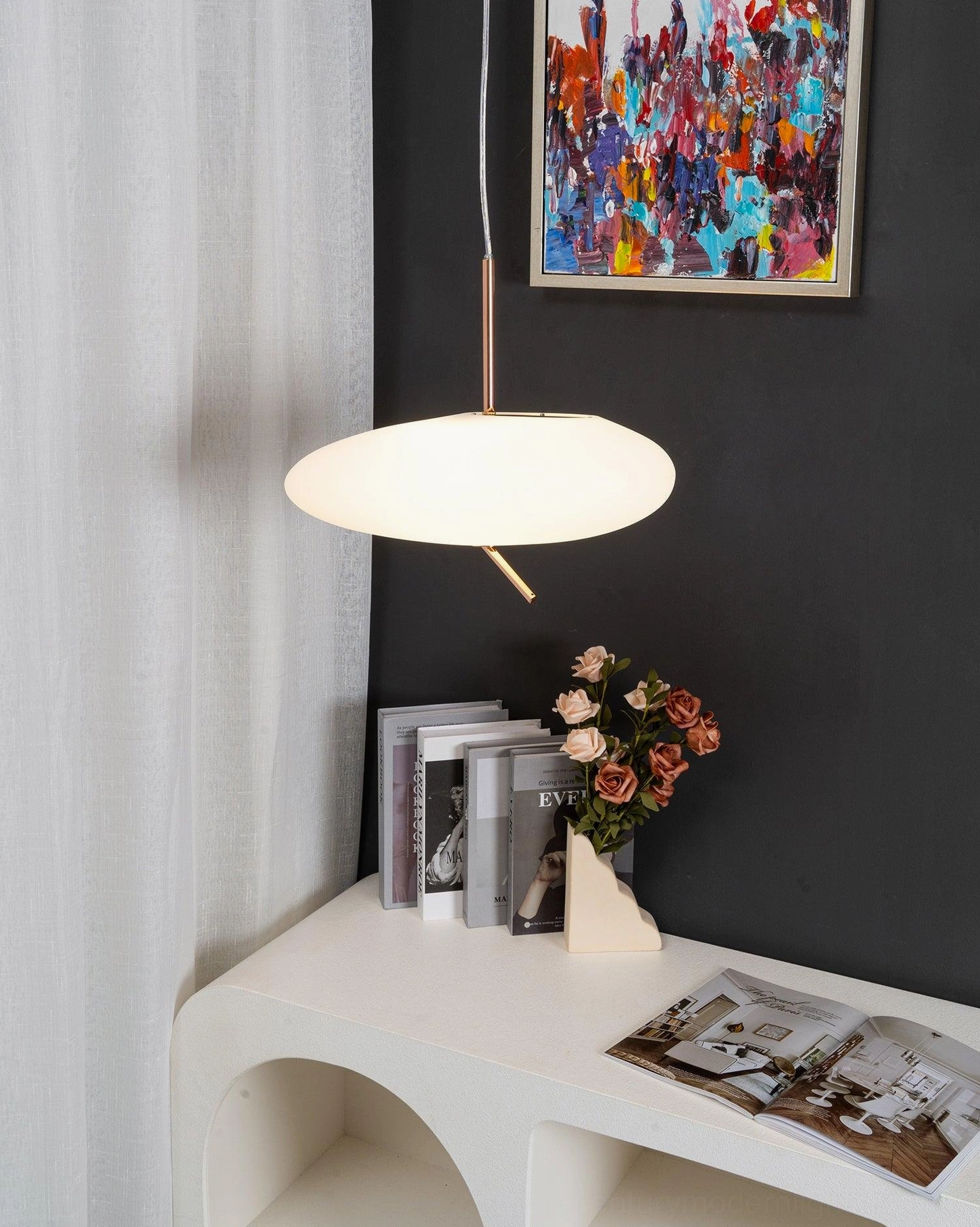 Pebbles pendant light in modern master bedroom with side view, green plants and dark fabric headboard