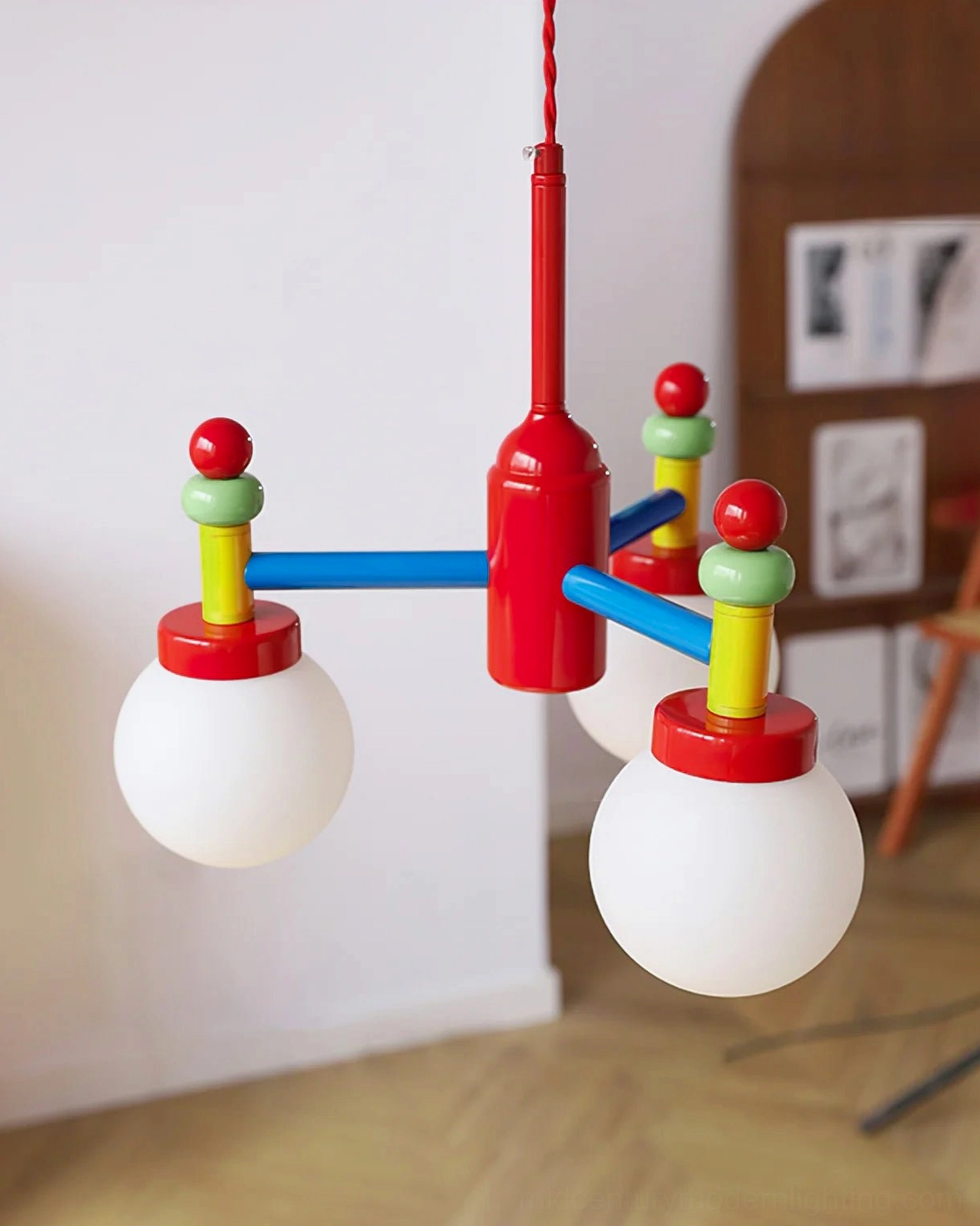 Three-quarter view of colorful pendant fixture with red blue green metal accents on wooden interior