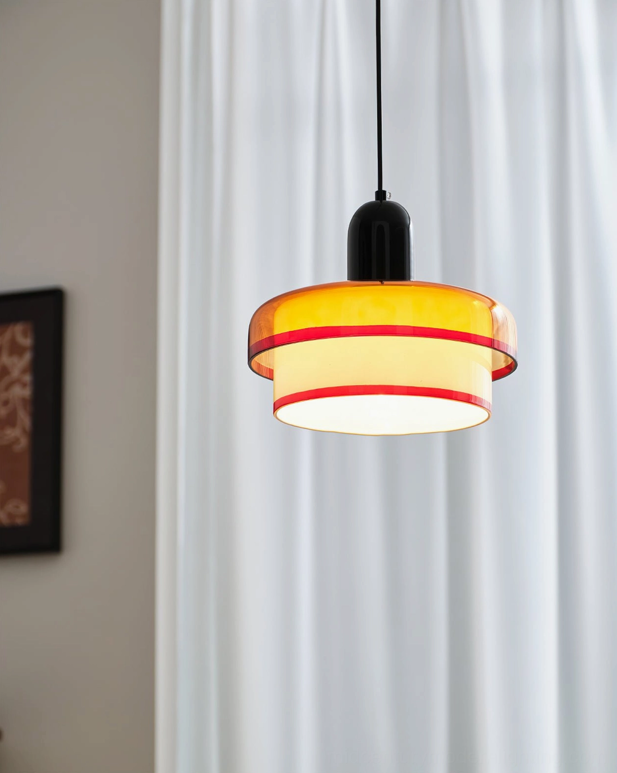 Hanging pendant light creating warm ambiance with orange red and white layered glass shade